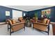 Living room featuring navy blue accent wall, piano, modern furniture, and natural lighting at 1658 Mount Paran Nw Rd, Atlanta, GA 30327