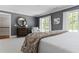 Spacious main bedroom featuring a round mirror, large windows, and stylish furnishings at 1658 Mount Paran Nw Rd, Atlanta, GA 30327