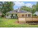 The backyard has a wooden deck and steps leading down to the grassy lawn and features a white home exterior at 1721 Druids Se Xing, Conyers, GA 30013