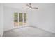 Bright bedroom with neutral carpet, large window view, and lighted ceiling fan at 1721 Druids Se Xing, Conyers, GA 30013