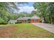 Inviting exterior view of a well-maintained home with a spacious front yard and mature trees at 1721 Druids Se Xing, Conyers, GA 30013