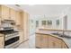 Kitchen featuring breakfast nook, stainless steel oven, cooktop, plenty of cabinet space, and white tile flooring at 1721 Druids Se Xing, Conyers, GA 30013