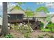 Lovely backyard showcasing a deck, a screened-in porch, mature trees and lush landscaping at 1894 Whitehawk Ct, Lawrenceville, GA 30043