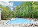 Community pool area with plenty of lounge chairs surrounded by a lush green landscape at 1894 Whitehawk Ct, Lawrenceville, GA 30043