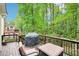 Inviting deck with seating and grill, overlooking a lush, wooded backyard at 1894 Whitehawk Ct, Lawrenceville, GA 30043