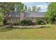 The spacious backyard offers a wood pile, shrubs, and the back of the home at 2301 Sharon Se Ct, Conyers, GA 30013