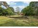 The expansive backyard has mature trees and a pile of cut logs at 2301 Sharon Se Ct, Conyers, GA 30013