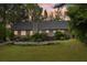 The large, grassy backyard has mature trees, shrubs, and the back of the house at 2301 Sharon Se Ct, Conyers, GA 30013