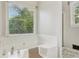 The bathroom has a modern white bathtub, and a window that offers natural lighting at 2301 Sharon Se Ct, Conyers, GA 30013