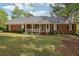 Charming single-story brick home featuring a welcoming front porch and a well-maintained lawn with mature trees at 2301 Sharon Se Ct, Conyers, GA 30013