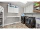 Spacious laundry room with modern appliances, tile floors, storage cabinets, and a folding table at 2301 Sharon Se Ct, Conyers, GA 30013