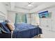 A main bedroom featuring a tray ceiling, a TV, and an ensuite bathroom, creating a relaxing retreat at 2301 Sharon Se Ct, Conyers, GA 30013