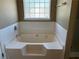 This bathroom features a traditional bathtub with tile surround and a window that provides natural light at 4234 Winston Cir, Atlanta, GA 30349
