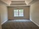 This bedroom features a tray ceiling, neutral-toned walls, and large window that allows an abundance of natural light at 4234 Winston Cir, Atlanta, GA 30349