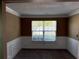 Bright living room featuring neutral carpet, beautiful wainscoting, and large windows at 4234 Winston Cir, Atlanta, GA 30349