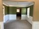 Spacious living room featuring neutral carpet, classic wainscoting, and windows providing natural light at 4234 Winston Cir, Atlanta, GA 30349