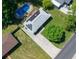 Aerial view of a home with solar panels, driveway, lush lawn, and in-ground pool at 724 Camelot Way, Norcross, GA 30071