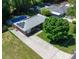 An aerial view of a brick home featuring solar panels, a long driveway, and a backyard swimming pool at 724 Camelot Way, Norcross, GA 30071