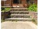 Back patio concrete steps lead to a brick house with wood trim and partial green grass at 724 Camelot Way, Norcross, GA 30071