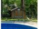 Outdoor shed and sparkling blue pool for relaxing and entertaining in a private backyard setting at 724 Camelot Way, Norcross, GA 30071