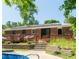 Charming backyard featuring a wooden deck, stone steps, in-ground pool, and solar panels at 724 Camelot Way, Norcross, GA 30071