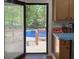 View from inside of backyard pool area beyond deck, through screened doors at 724 Camelot Way, Norcross, GA 30071