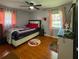 Cozy bedroom features hardwood floors, natural light, and a ceiling fan at 724 Camelot Way, Norcross, GA 30071