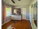 Well-lit bedroom with hardwood floors, dresser, and view from the window at 724 Camelot Way, Norcross, GA 30071