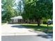 A charming brick home featuring mature trees, dark shutters, an extended driveway, and a black mailbox at 724 Camelot Way, Norcross, GA 30071