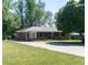 Charming brick home with a well-maintained front lawn, mature tree, and a paved driveway at 724 Camelot Way, Norcross, GA 30071