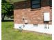 Exterior view showcasing the brick siding and Tesla Powerwall on a lush green lawn at 724 Camelot Way, Norcross, GA 30071