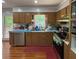 Functional kitchen with wooden cabinetry, a window over the sink, and wood-look flooring at 724 Camelot Way, Norcross, GA 30071