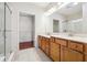 Bright bathroom with double vanity, glass-enclosed shower, and access to a walk-in closet at 1410 Bluestone Dr, Cumming, GA 30041