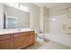 Bright bathroom featuring a wooden vanity with large mirror and a bathtub with shower at 1410 Bluestone Dr, Cumming, GA 30041