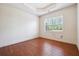 The bedroom has hardwood floors, a tray ceiling, and a large window overlooking greenery, creating a peaceful retreat at 1410 Bluestone Dr, Cumming, GA 30041