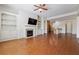 Open-concept living room featuring hardwood floors, a fireplace, built-ins, and seamless flow to the kitchen at 1410 Bluestone Dr, Cumming, GA 30041