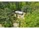 A cozy house with a metal roof sits in a verdant, tree-filled lot, offering a private and peaceful setting at 1530 Mcbrayer Rd, Temple, GA 30179