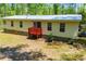The home's rear view features a red deck, sliding glass door, and a well-maintained yard, perfect for outdoor enjoyment at 1530 Mcbrayer Rd, Temple, GA 30179