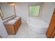 Bright bathroom featuring tile flooring, double sinks, and a corner soaking tub at 1530 Mcbrayer Rd, Temple, GA 30179