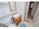 A bathroom featuring a toilet, sink, wooden vanity, a wall mirror, and an open doorway at 1530 Mcbrayer Rd, Temple, GA 30179