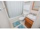 A bathroom with a tiled floor, a toilet, a wooden vanity, and a shower with a shower curtain at 1530 Mcbrayer Rd, Temple, GA 30179