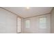 An empty bedroom with two windows, neutral carpet, and a door leading to another room at 1530 Mcbrayer Rd, Temple, GA 30179