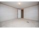 An empty bedroom with neutral carpet, a door leading to another room, and two electrical outlets at 1530 Mcbrayer Rd, Temple, GA 30179