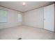 Bedroom with neutral carpet, two large windows, and one white door at 1530 Mcbrayer Rd, Temple, GA 30179