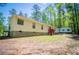 The exterior is beige siding with brick foundation and a red deck, surrounded by trees at 1530 Mcbrayer Rd, Temple, GA 30179