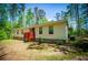 The exterior is beige siding, brick foundation, red deck and a wooded backyard at 1530 Mcbrayer Rd, Temple, GA 30179