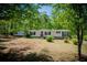 Charming one-story home nestled amongst mature trees, with a bright red front door and well-maintained landscaping at 1530 Mcbrayer Rd, Temple, GA 30179
