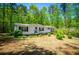 Inviting one-story home with neutral siding, black shutters, a red front door, and well-maintained landscaping at 1530 Mcbrayer Rd, Temple, GA 30179