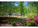 Beautiful one-story home with well-maintained landscaping with a bright red door, and is surrounded by mature trees at 1530 Mcbrayer Rd, Temple, GA 30179