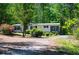 Beautiful one-story home with black shutters and colorful landscaping along a private driveway surrounded by mature trees at 1530 Mcbrayer Rd, Temple, GA 30179